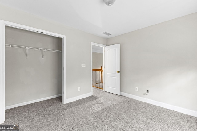 unfurnished bedroom with carpet floors, a closet, visible vents, and baseboards