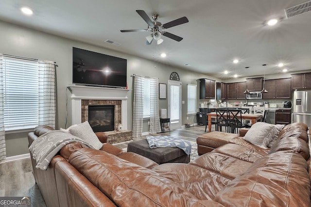 living room featuring light wood-type flooring, visible vents, and recessed lighting