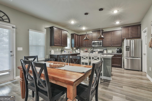 dining area featuring recessed lighting, light wood-style flooring, and baseboards