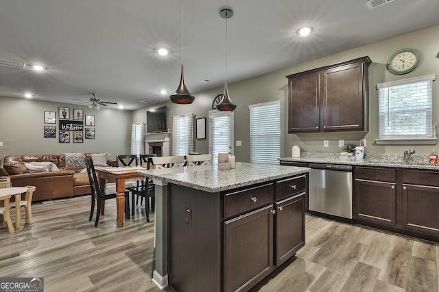 kitchen featuring light wood finished floors, visible vents, dishwasher, dark brown cabinets, and a fireplace