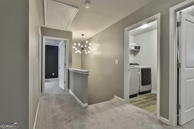 hallway with an upstairs landing, attic access, carpet flooring, and independent washer and dryer