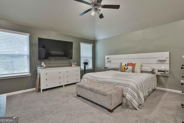 bedroom featuring lofted ceiling, multiple windows, baseboards, and carpet flooring