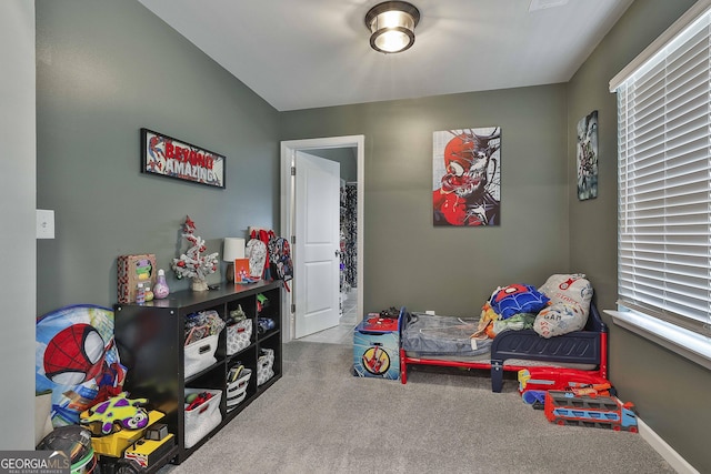 rec room with carpet floors, a healthy amount of sunlight, and baseboards