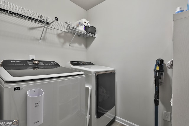 laundry room with laundry area, baseboards, and separate washer and dryer