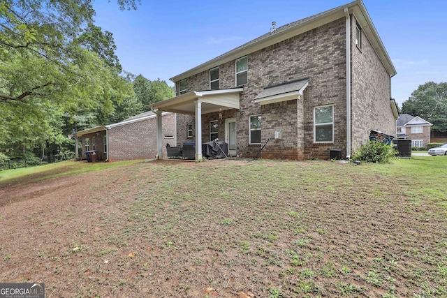 rear view of house featuring brick siding and a lawn