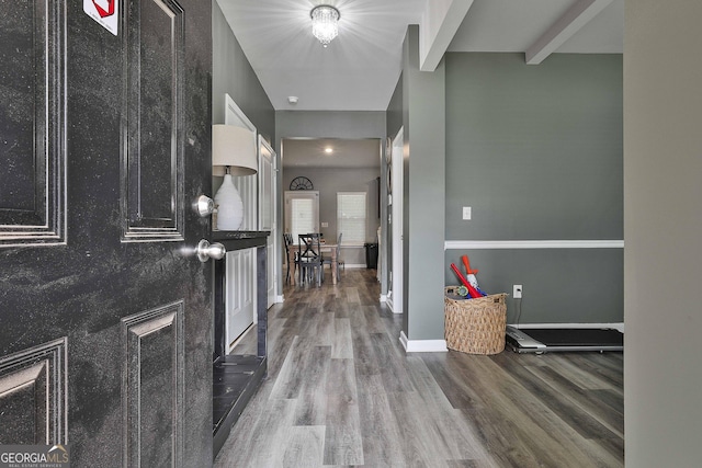 entrance foyer featuring baseboards, wood finished floors, and beamed ceiling