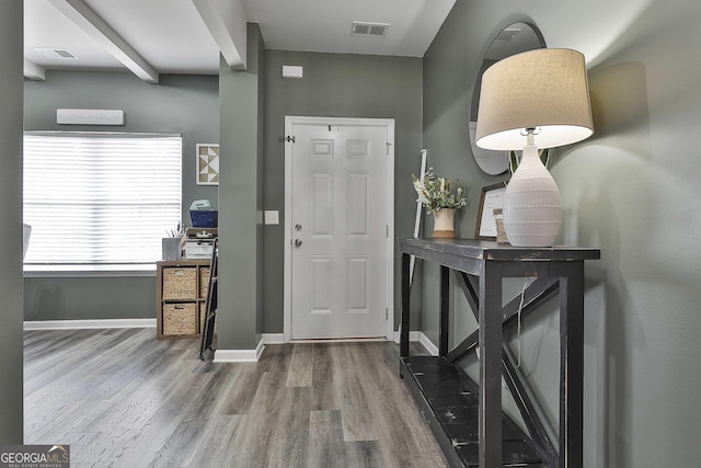 entryway featuring baseboards, visible vents, and wood finished floors