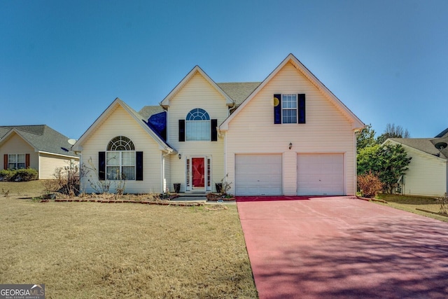 traditional-style house with a garage, a front yard, and concrete driveway