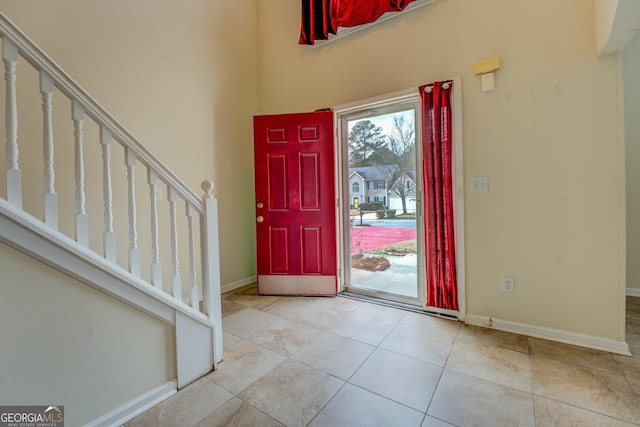 entryway featuring stairway, tile patterned floors, and baseboards