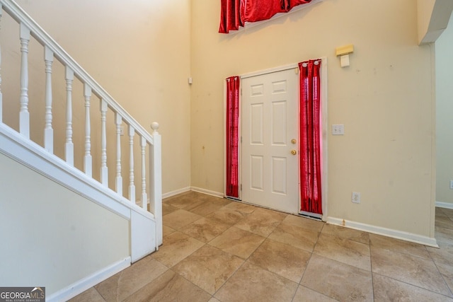 entrance foyer featuring stairway and baseboards