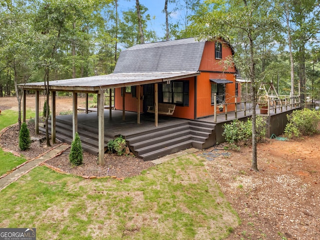 view of front of house featuring a front lawn and a gambrel roof