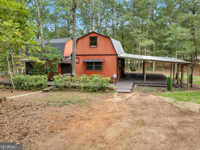 view of front facade with a barn, a shingled roof, and a gambrel roof