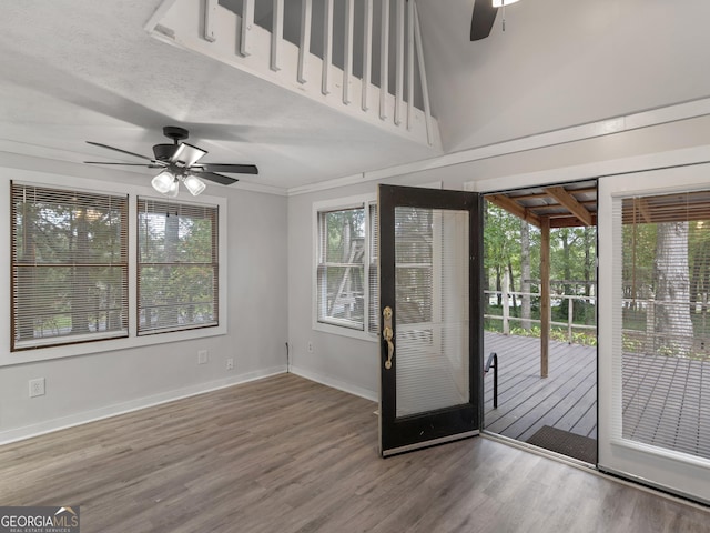 foyer featuring ceiling fan, wood finished floors, a towering ceiling, and baseboards