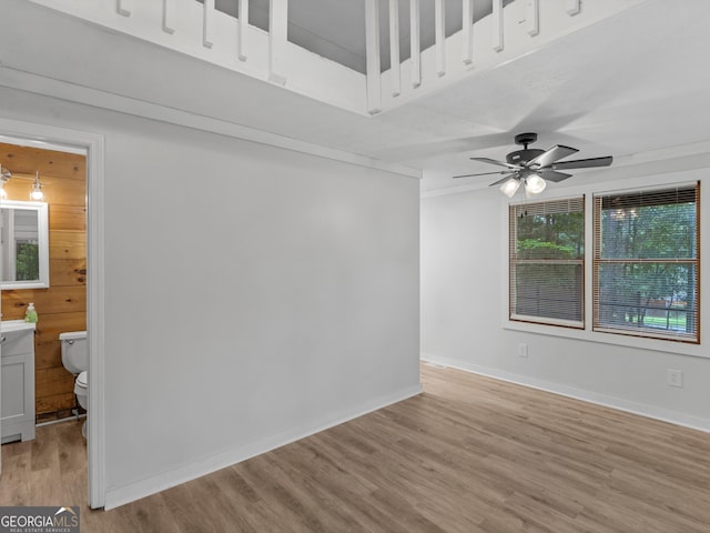 unfurnished room featuring a ceiling fan, light wood-style flooring, and baseboards