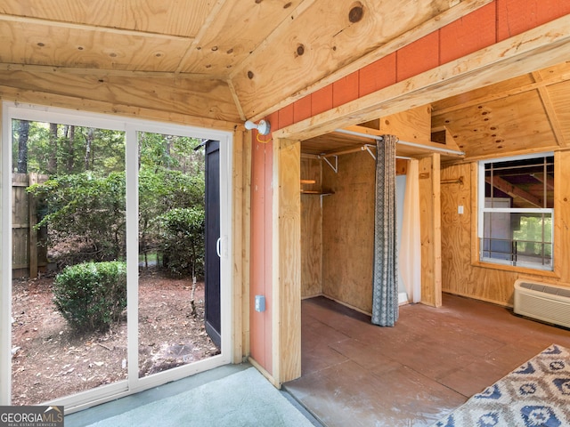 interior space with lofted ceiling and an AC wall unit