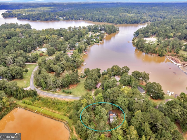 aerial view with a water view and a forest view