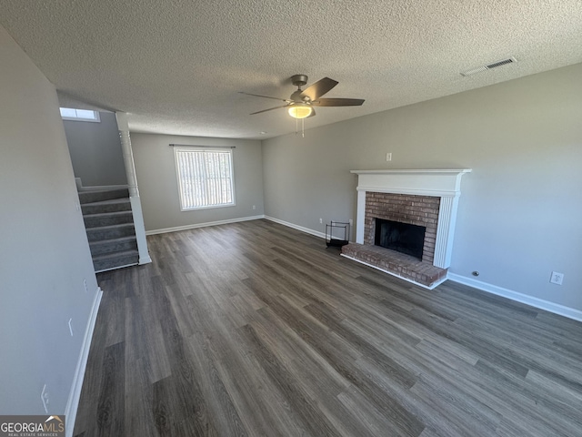 unfurnished living room with a fireplace, dark wood finished floors, baseboards, and stairs