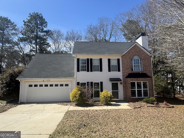 colonial inspired home with a garage, driveway, a chimney, and a shingled roof