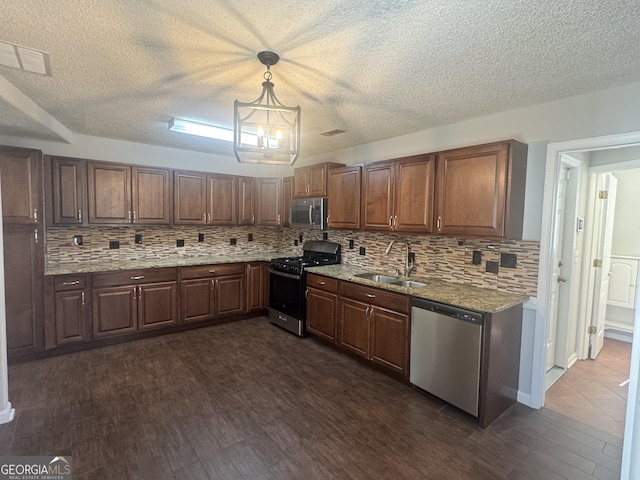 kitchen with tasteful backsplash, dark wood-style flooring, stainless steel appliances, and a sink