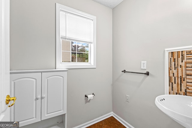 bathroom with a textured ceiling and baseboards