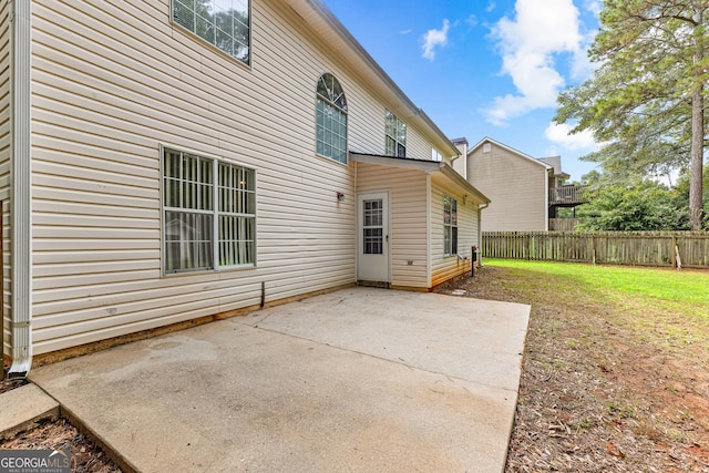 rear view of house featuring a yard, a patio area, and fence