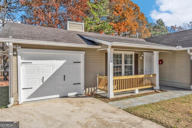 view of front facade featuring a chimney, a shingled roof, covered porch, an attached garage, and driveway