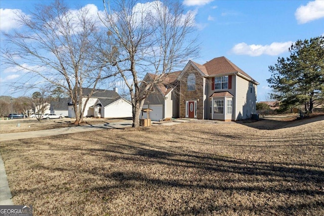 traditional home featuring a front yard, cooling unit, and driveway