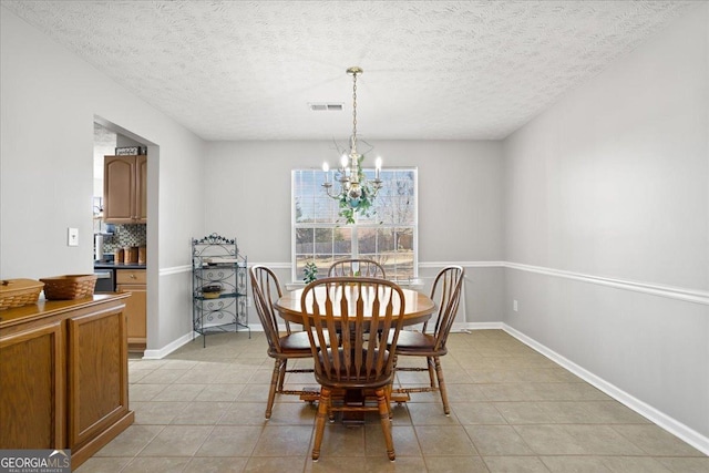 dining room featuring light tile patterned floors, baseboards, visible vents, and a chandelier