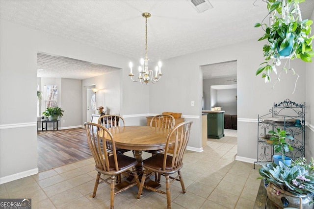 dining room featuring baseboards, visible vents, a textured ceiling, and light tile patterned flooring