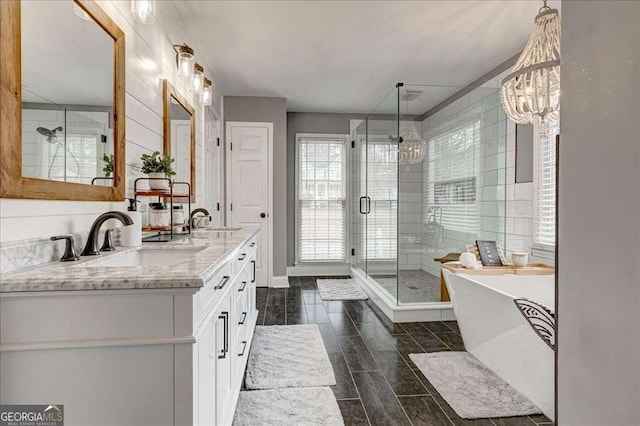 bathroom featuring double vanity, a stall shower, a soaking tub, and a sink