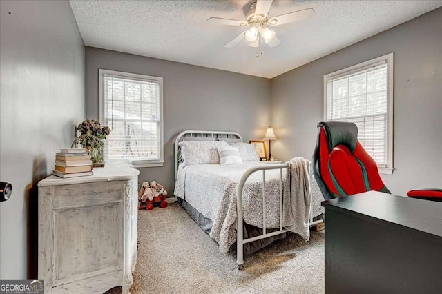 bedroom with a textured ceiling, ceiling fan, and carpet