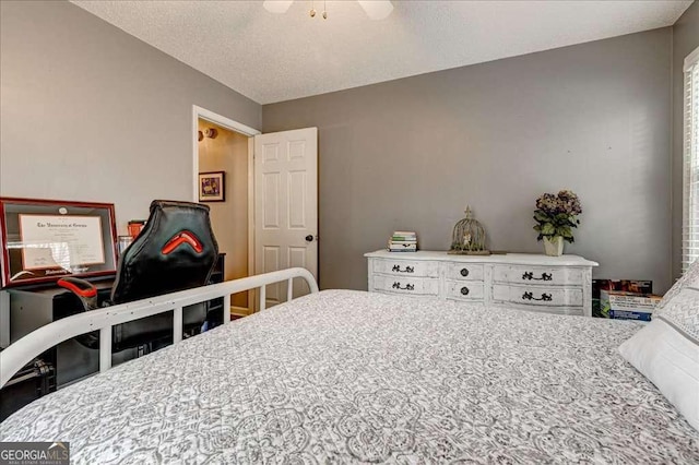 bedroom with ceiling fan and a textured ceiling