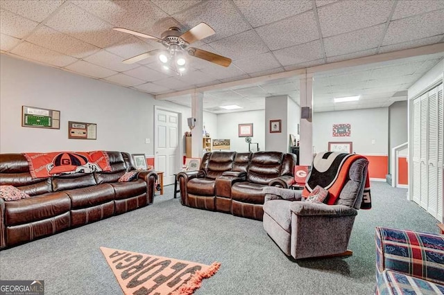 living area featuring carpet floors, a ceiling fan, and a paneled ceiling