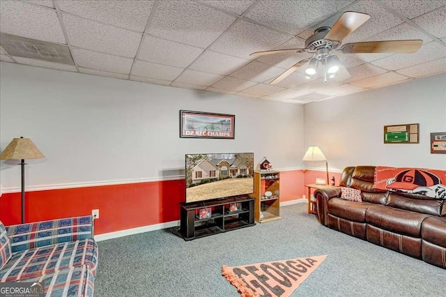 carpeted living room with a paneled ceiling, visible vents, ceiling fan, and baseboards