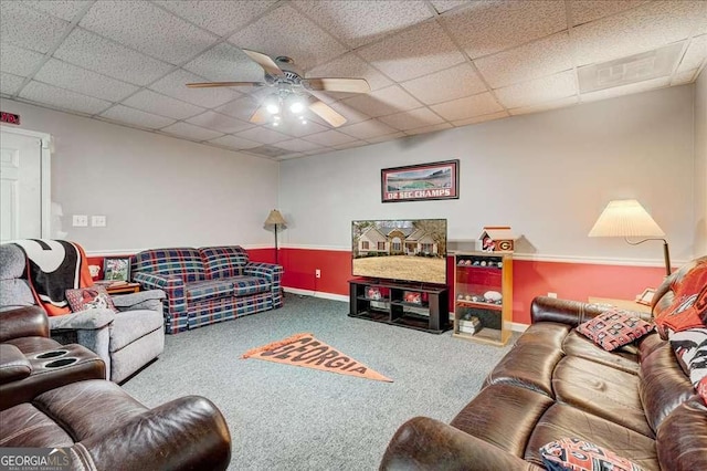 living area with a ceiling fan, carpet flooring, and a drop ceiling