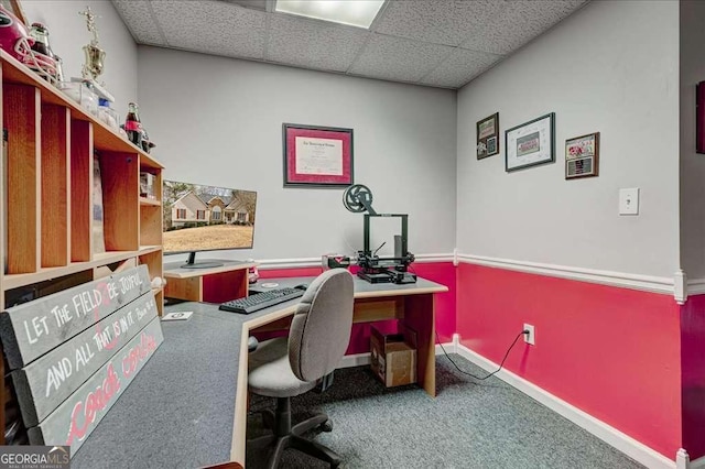 carpeted home office with a paneled ceiling and baseboards