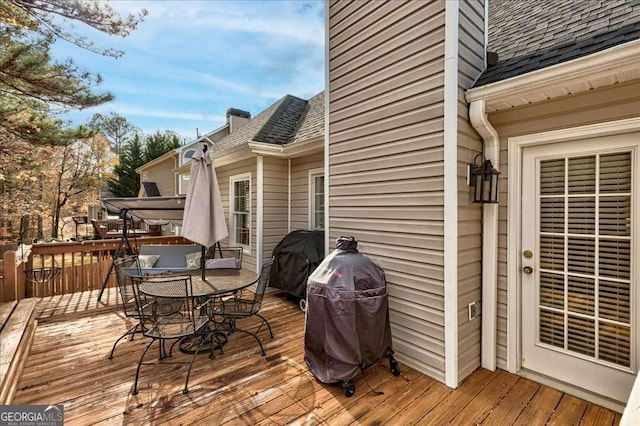 deck with outdoor dining area and grilling area