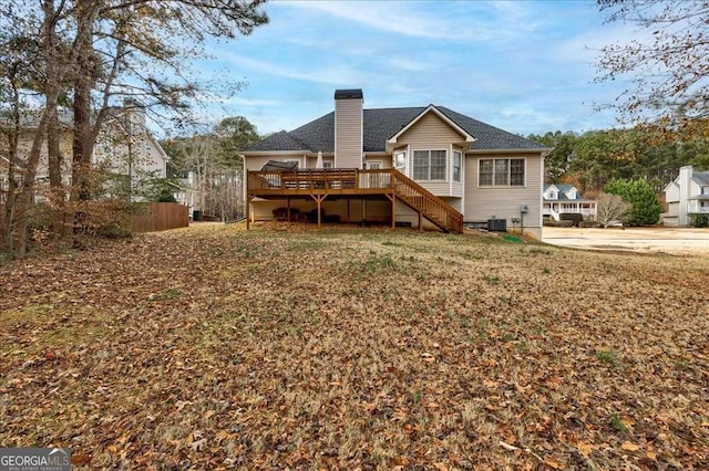 back of house featuring a chimney, a wooden deck, and stairs