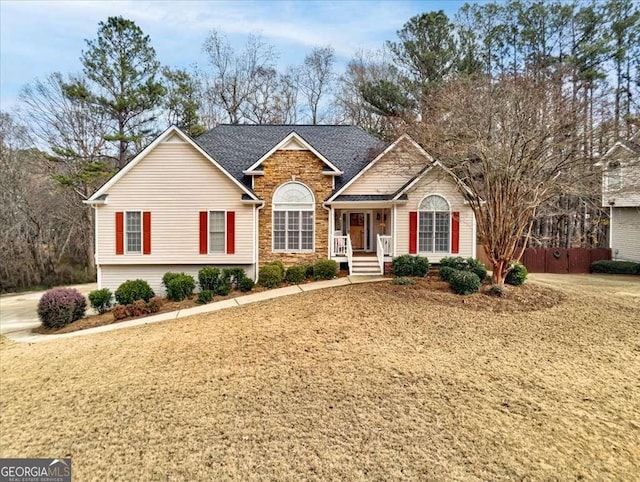 single story home featuring stone siding and roof with shingles