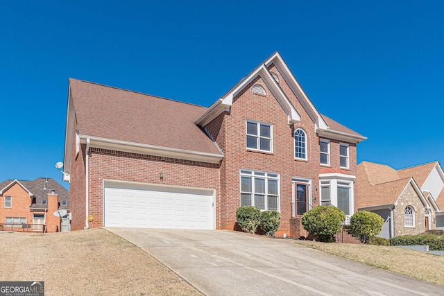 view of front of property featuring driveway, roof with shingles, a garage, and brick siding