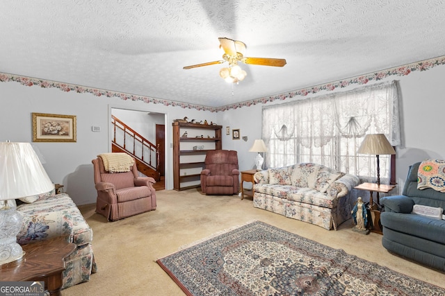 living room with ceiling fan, a textured ceiling, and carpet flooring