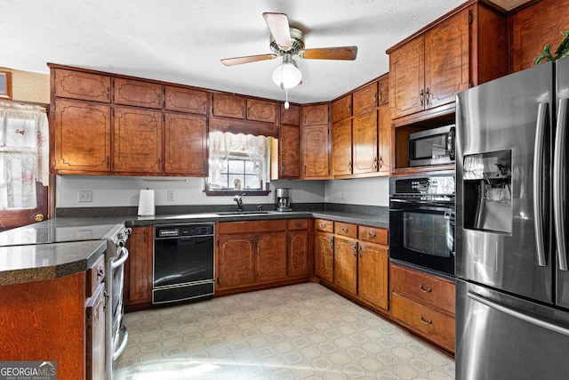 kitchen with dark countertops, brown cabinets, a sink, and black appliances