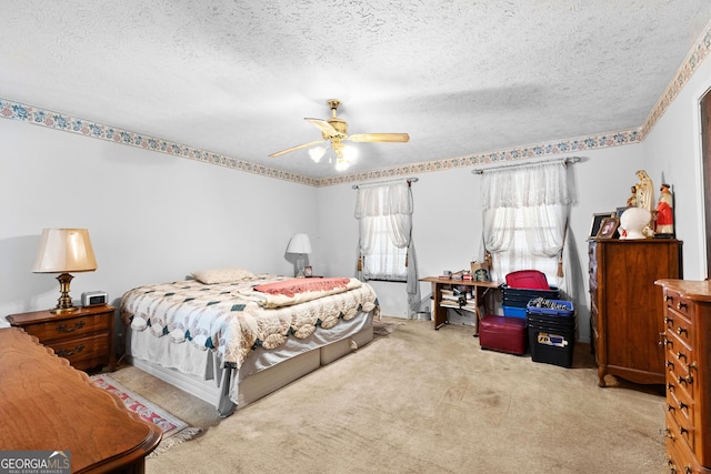 carpeted bedroom featuring a ceiling fan and a textured ceiling