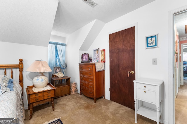 bedroom with light carpet, visible vents, and a textured ceiling