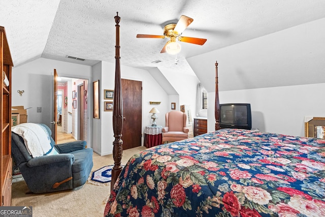 carpeted bedroom featuring a ceiling fan, visible vents, vaulted ceiling, and a textured ceiling