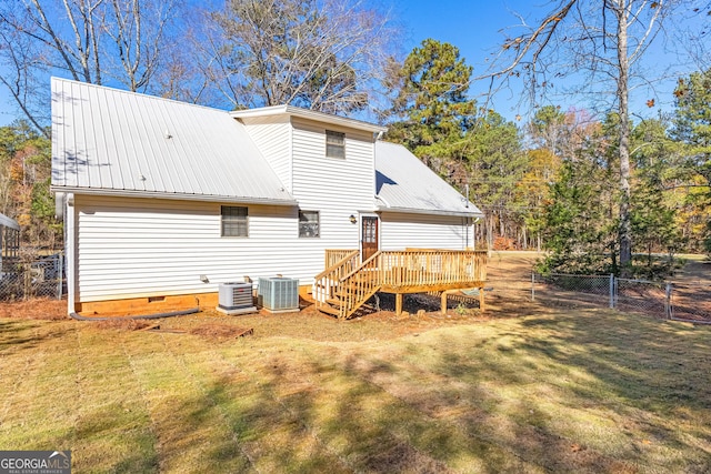 rear view of property with central AC, fence, metal roof, and a lawn