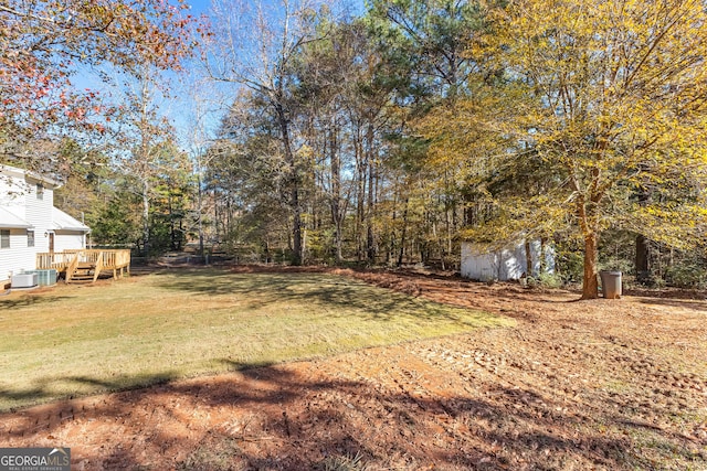 view of yard with a deck and central AC