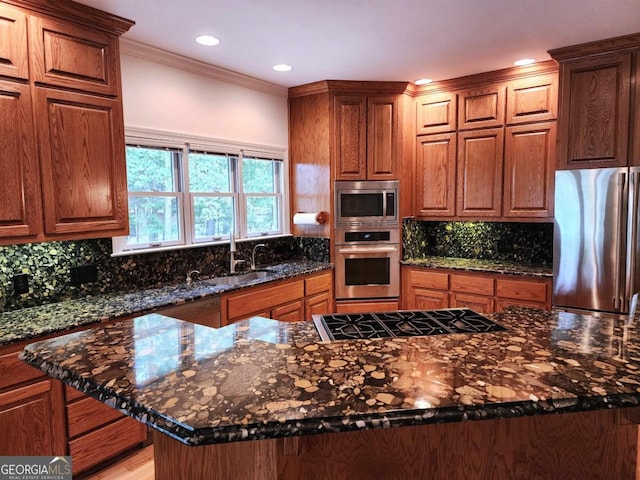 kitchen featuring stainless steel appliances, a sink, ornamental molding, dark stone counters, and tasteful backsplash