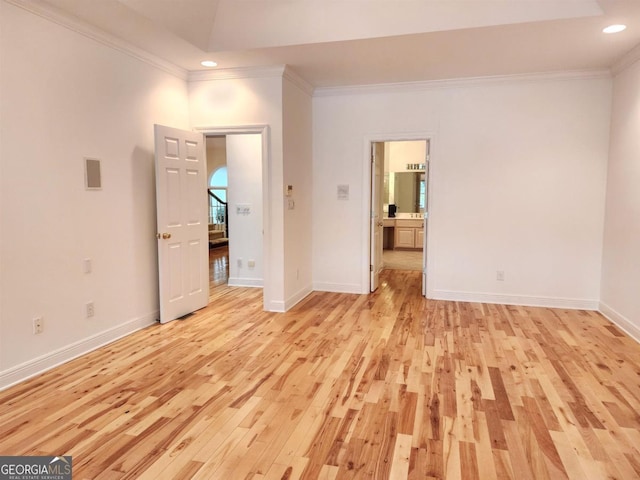 spare room with light wood finished floors, baseboards, ornamental molding, and recessed lighting