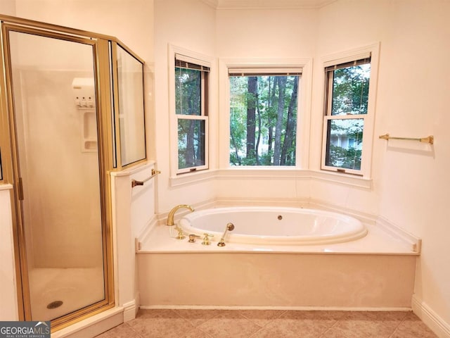 bathroom with baseboards, a shower stall, a bath, and tile patterned floors